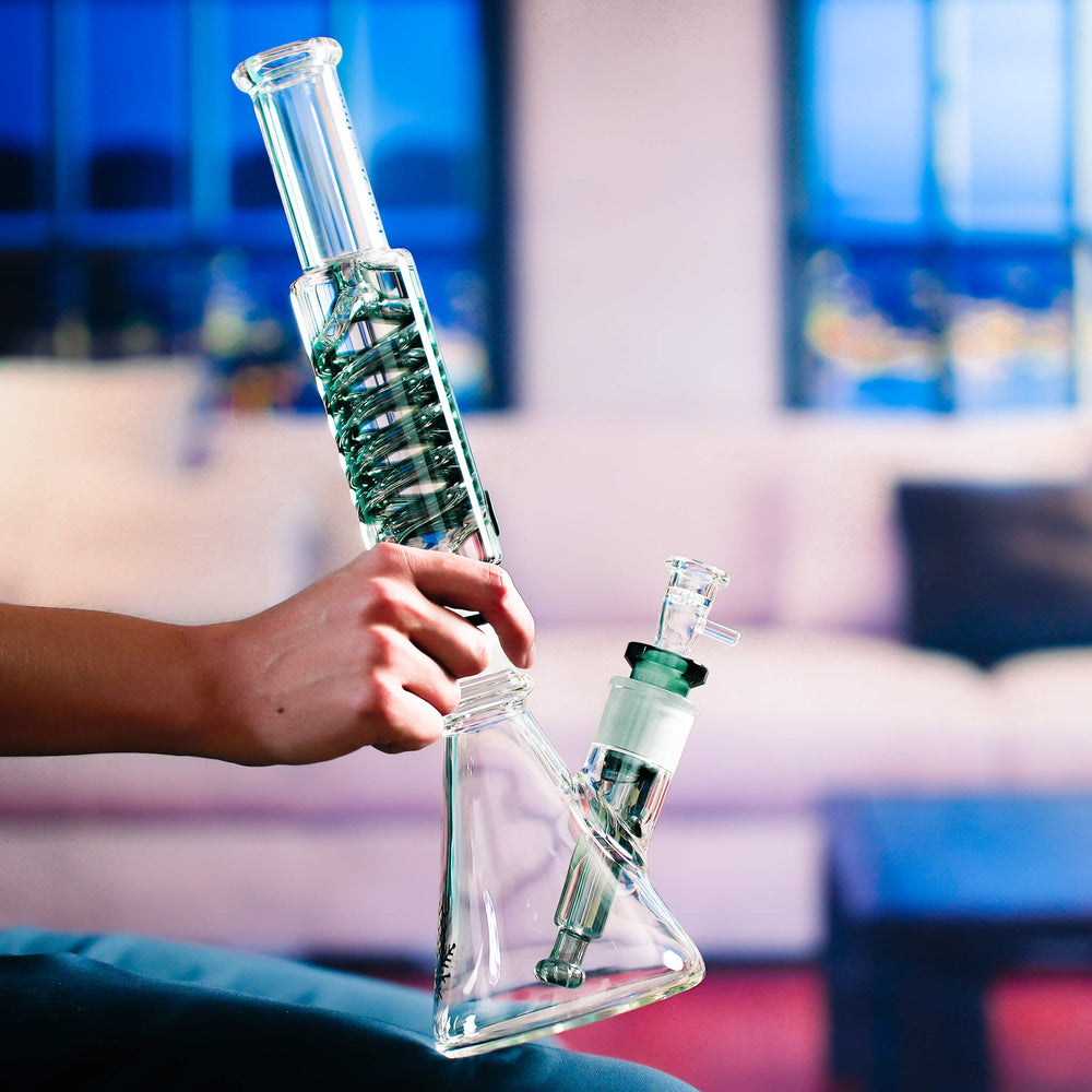 Holding a Beaker Bong Ultimate, showing the XL DNA Coil and the glycerin-filled downstem in the base